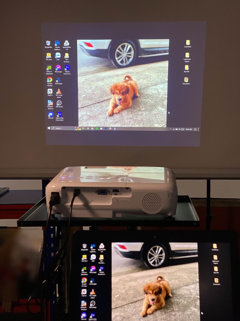 an Epson projector displays a laptop screen with a USB cable connection