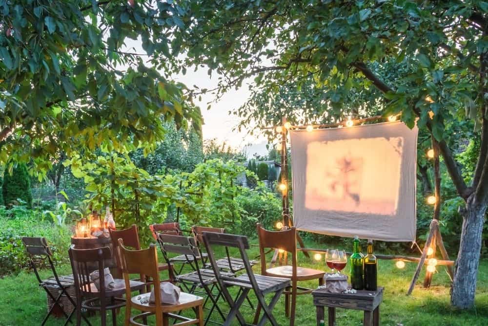 summer cinema in a garden with white sheet as a projector screen