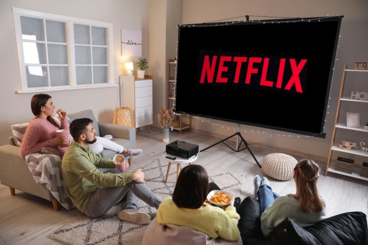 a group of people watching netflix with projector