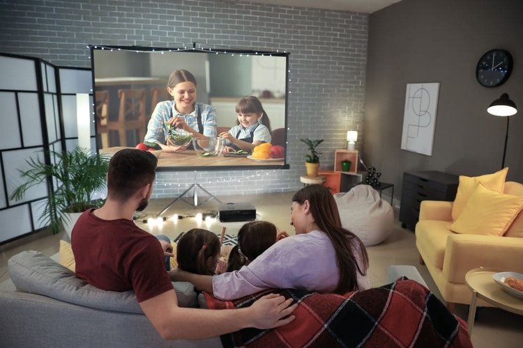 Familie schaut Film mit ALR-Projektorleinwand