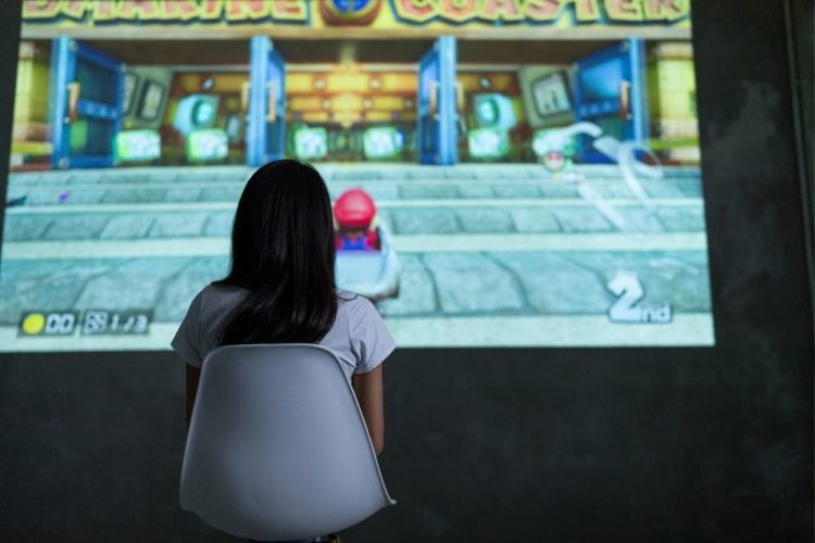 girl playing Nintendo Switch with a projector