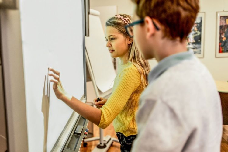 Zwei Klassenkameraden, die das Smartboard für ihr Projekt verwenden