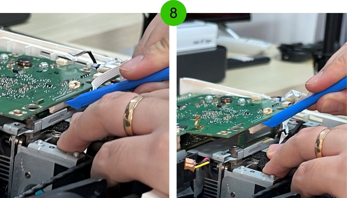 A hand is using the iFixit tool to disassemble a projector