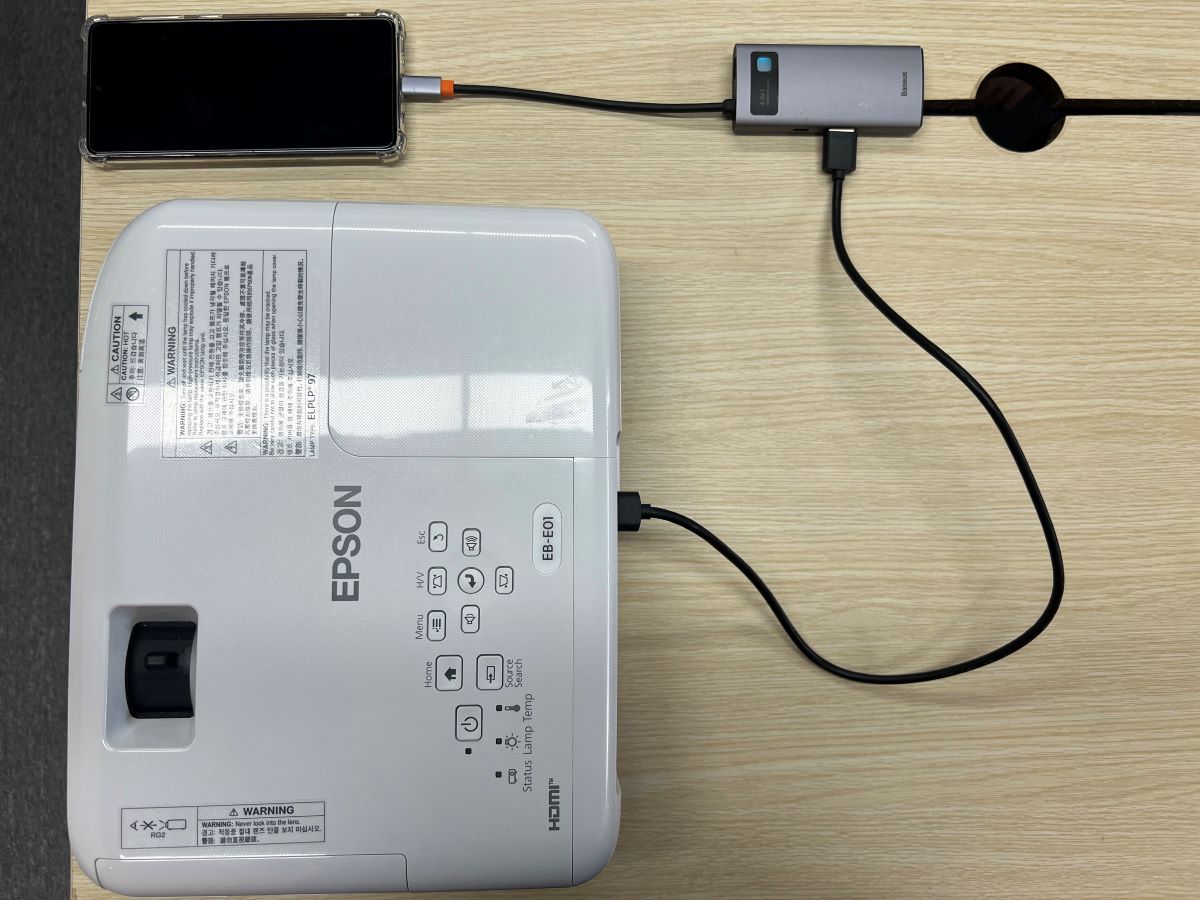 Samsung smartphone is connected to a USB-C to HDMI adapter and the HDMI is connected to Epson projector