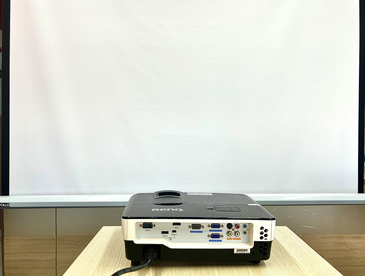 benq projector on a table in front of a projector screen