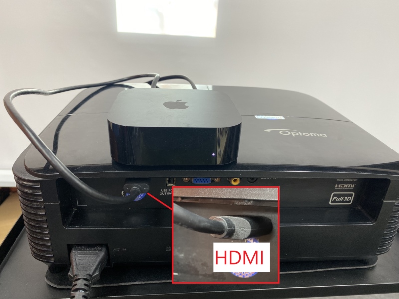An Apple TV is connecting to an Optoma projector via HDMI cable