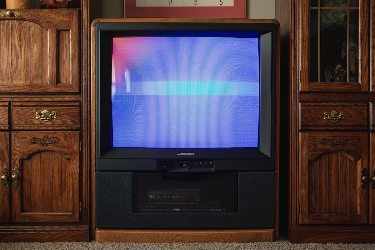 an old and big mitsubishi tv in an old tv cabinet