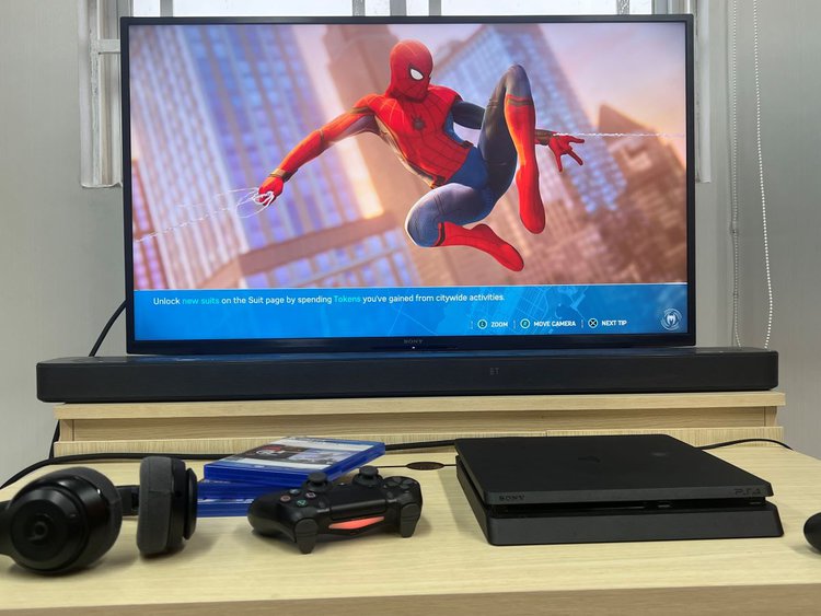 The Spider-man game on PS4 with Sony TV and the PS4 controller along side is a bear headphones