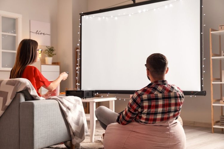 a couple sitting near a projector screen
