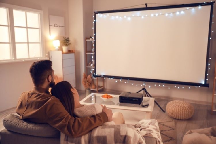 a couple using ultra short throw projector screen for movie night