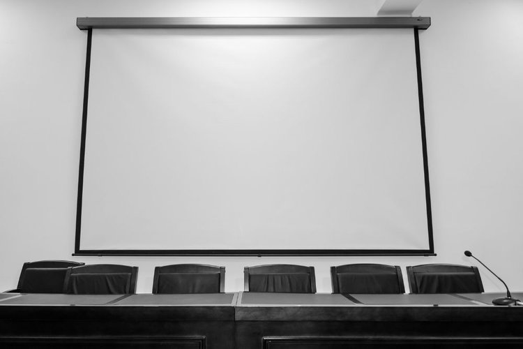 a pull down retractable projector screen in a meeting room