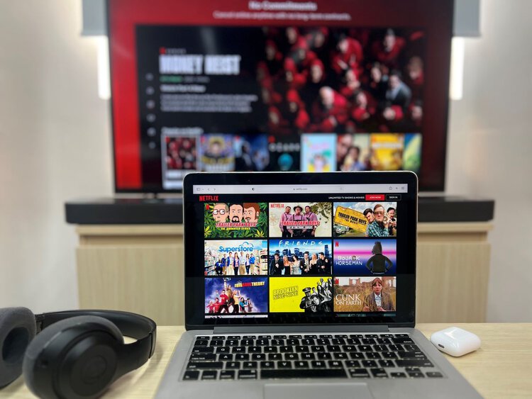 Netflix on MacBook and on TV with headphones around