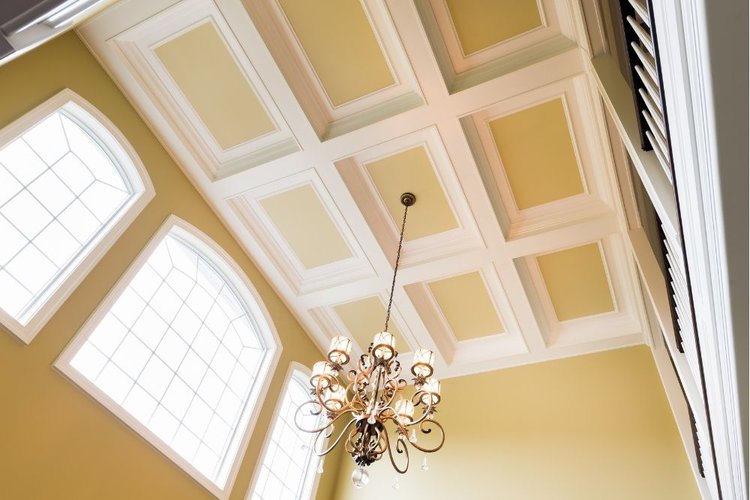 a coffered ceiling holds a chandelier