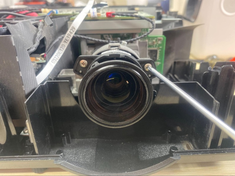 use a screwdriver to unscrew the projector lens out of the housing