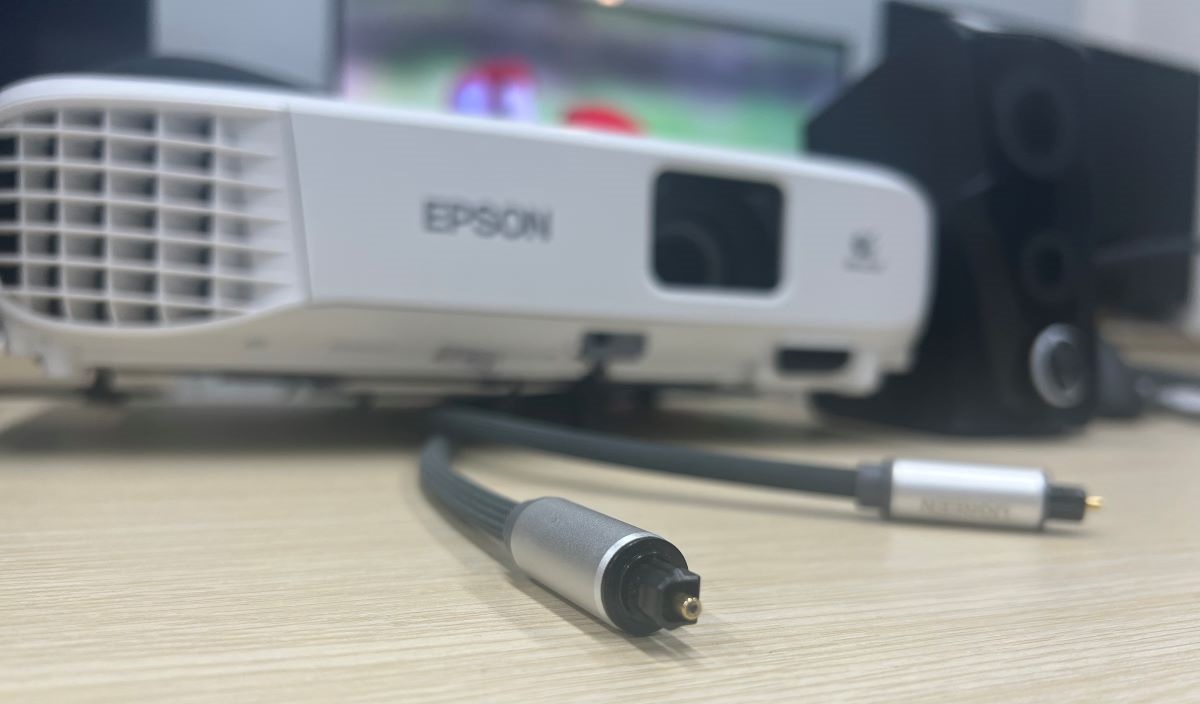 Optical cable is running under the Epson projector with the external speakers along side