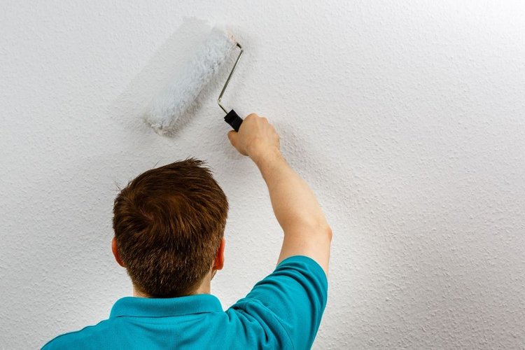 a man painting a white wall