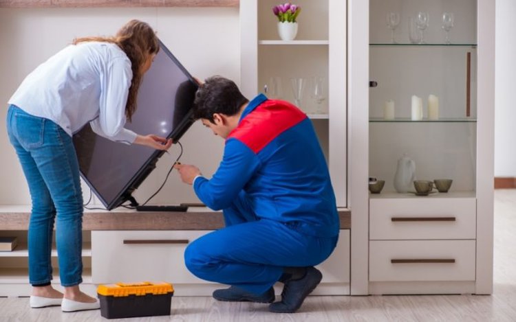 un hombre que repara un televisor