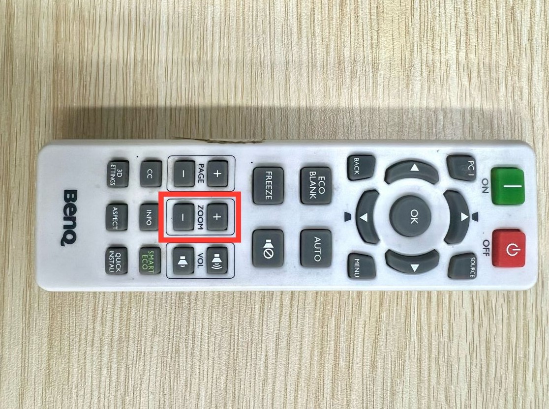 zoom in & out buttons are highlighted on a benq projector remote