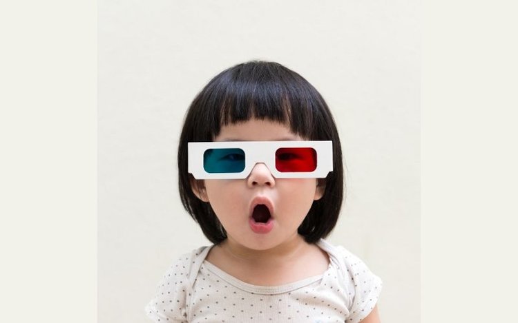 a girl wearing red-cyan anaglyph 3D glasses