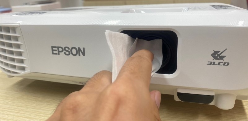 using a microfiber cloth to clean the Epson projector lens