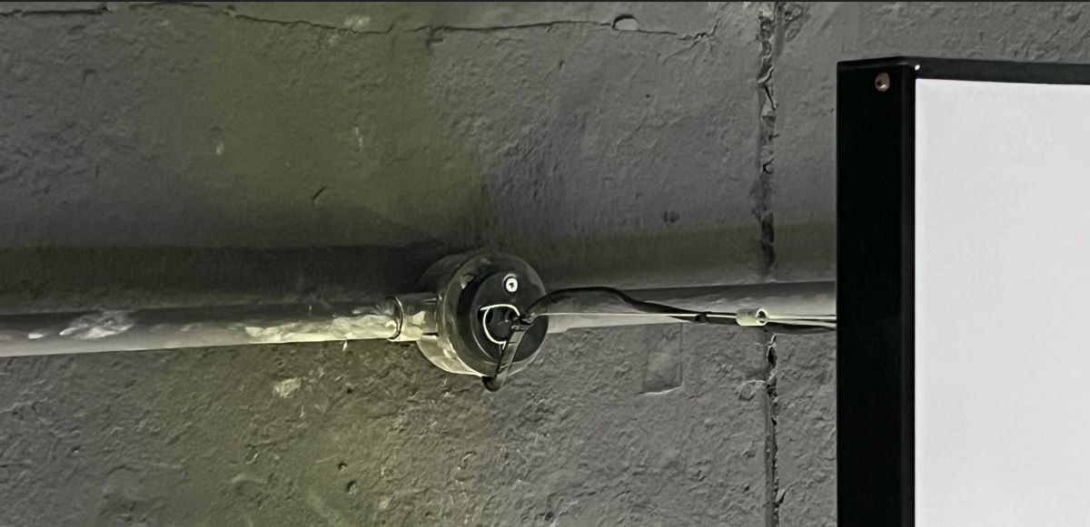 A PVC conduit on a black ceiling