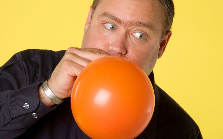 a man blowing up a baloon