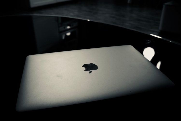 A Macbook on a black table