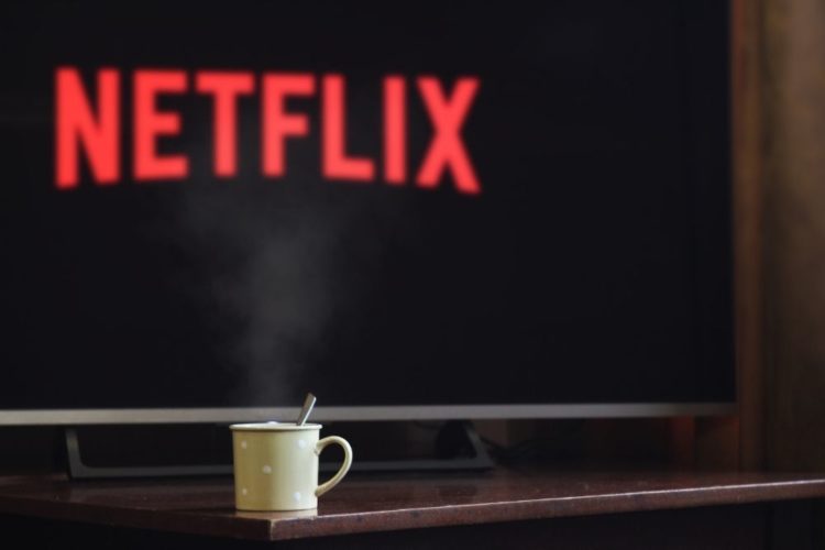 A TV opening Netflix and a cup of hot coffee