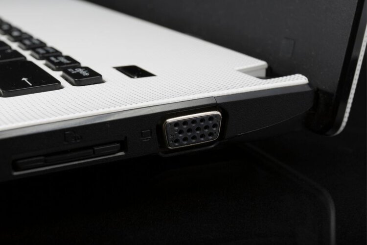A VGA port on a white laptop