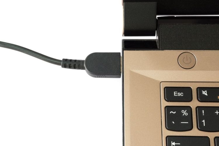 A bronze laptop is charging