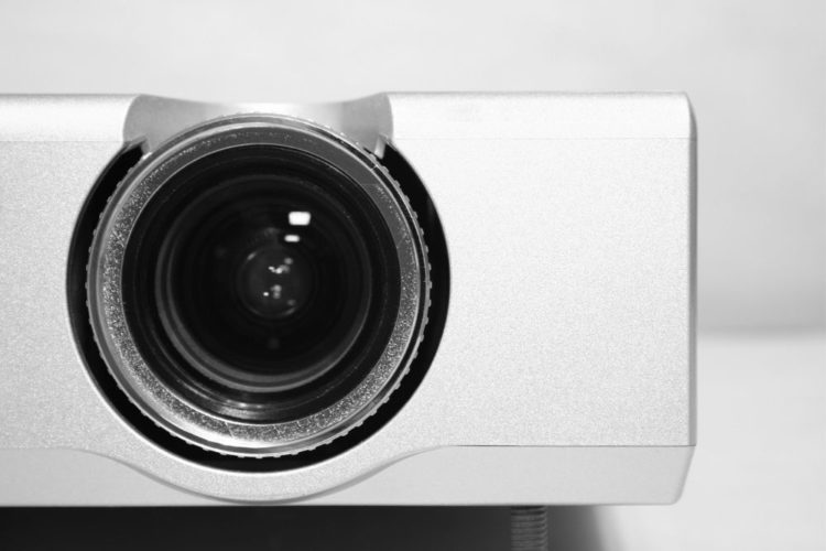 A close-up of white projector in a white room