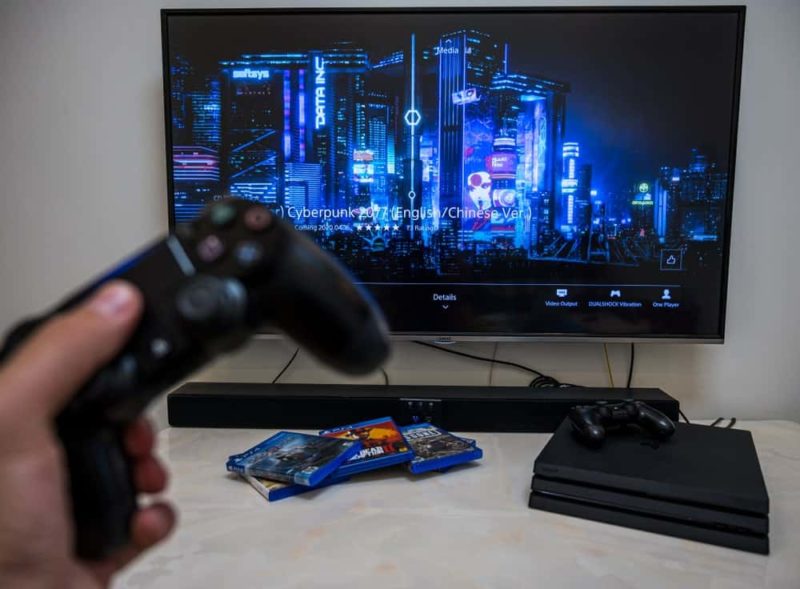 A guy is playing games on PS4 connecting to a TV with an HDMI cable