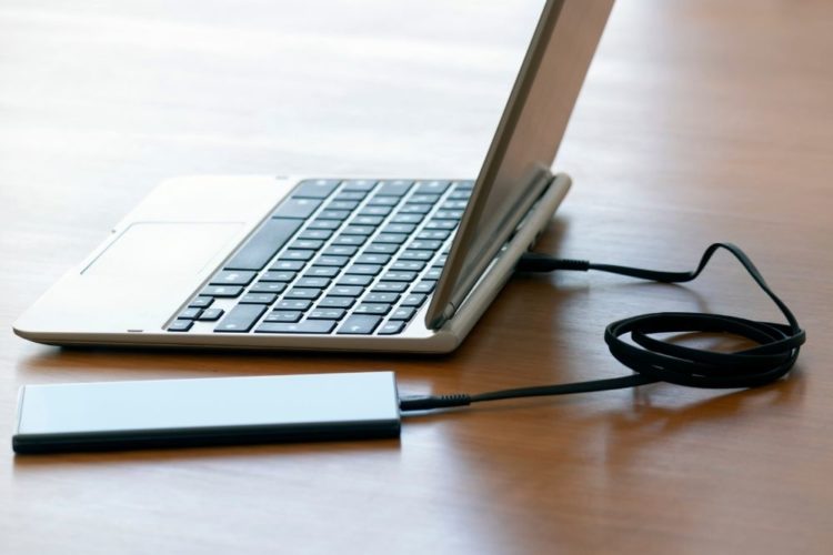 A laptop is charged by a power bank