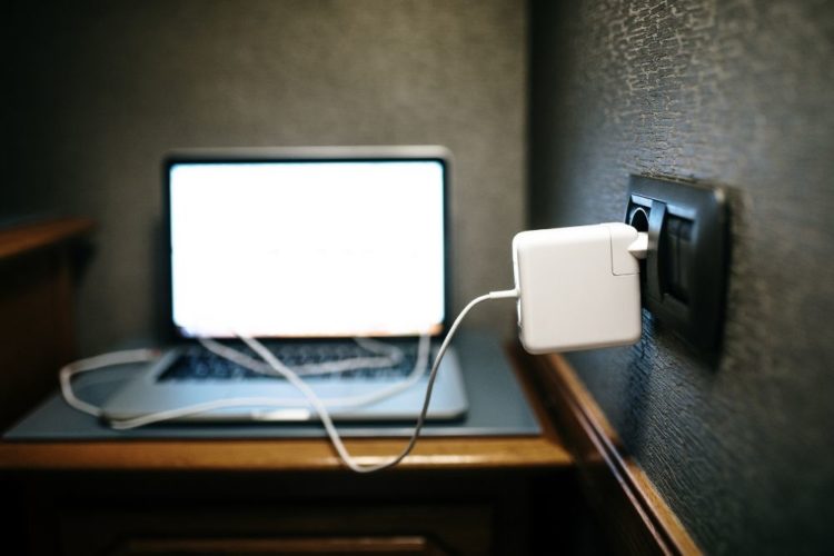 A laptop is charged by an USB Power Adapter