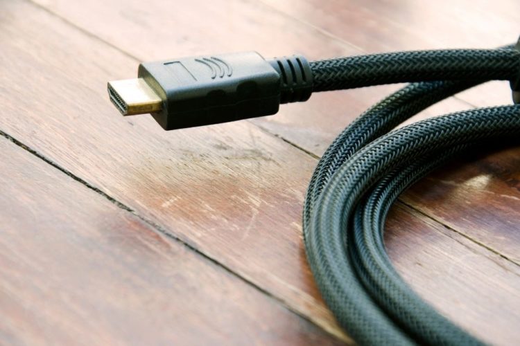 A long black hdmi cable on a wood table