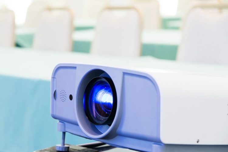 A purple projector in a white conference room