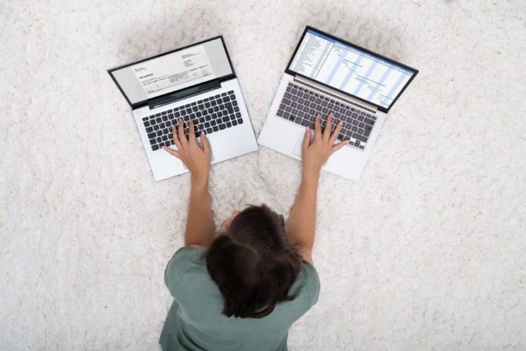 A woman using two laptops at the same time