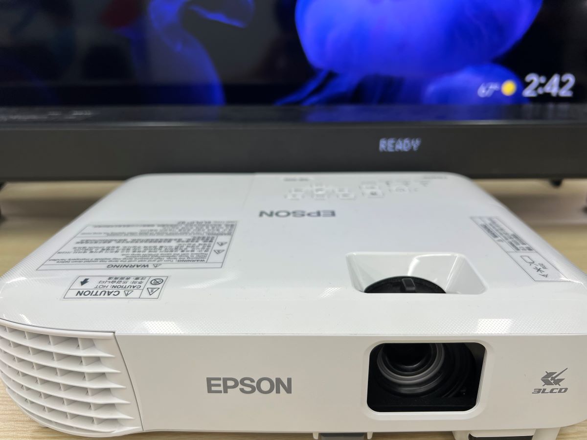 Epson projector with the LG soundbar at the back and the Sony TV is on showing a blue screen