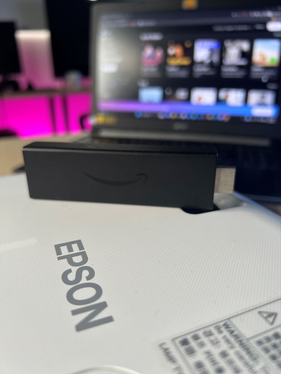 Fire TV Stick on top of the Epson projector and a Acer laptop at the background
