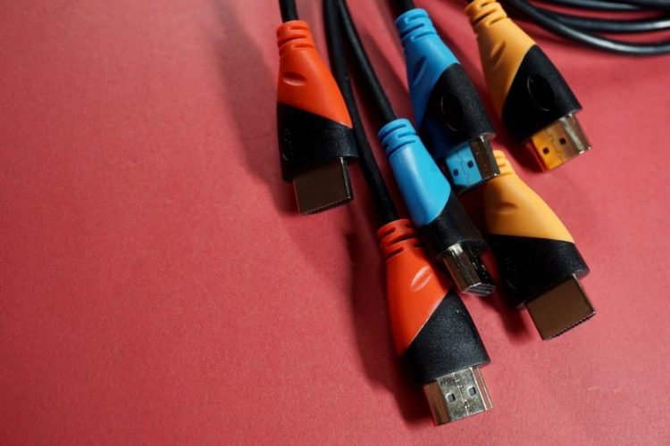 Multi-color hdmi cables on a red wall
