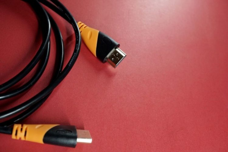 Orange hdmi cables on a red wall