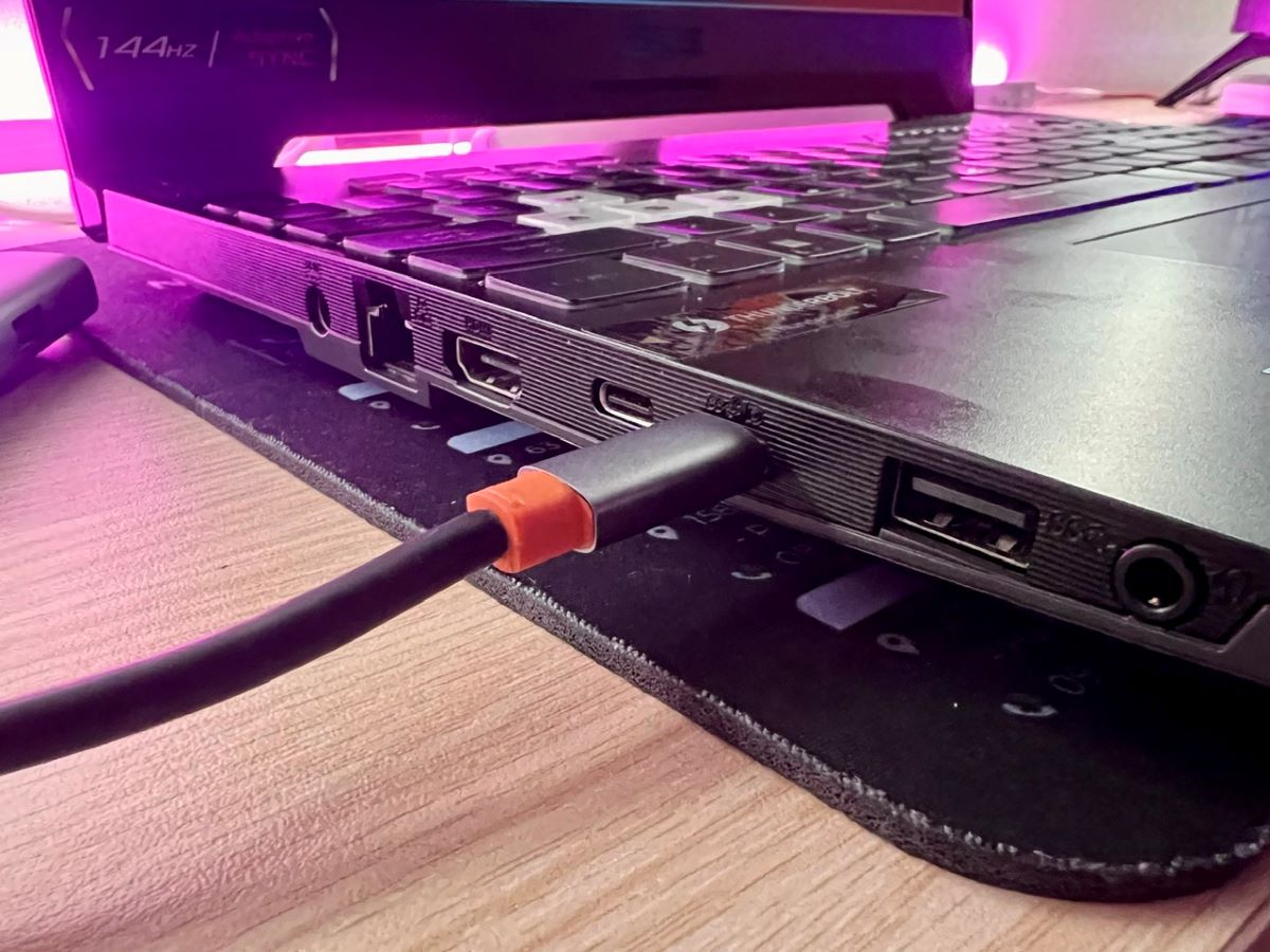 a hand plugging an adapter's usb-a end into a laptop's usb-c port