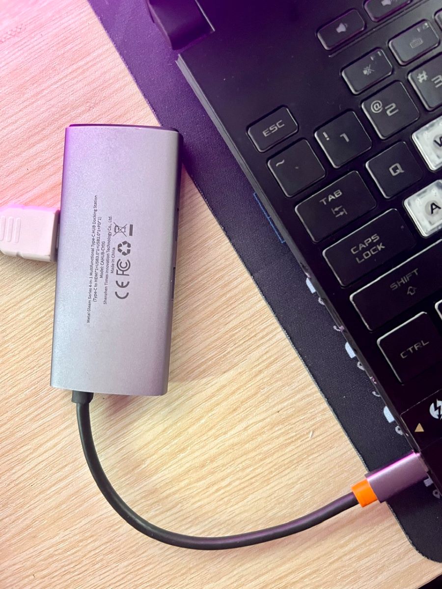 a usb-c to hdmi adapter is plugged with an hdmi cable and is plugged into a laptop's usb-c port