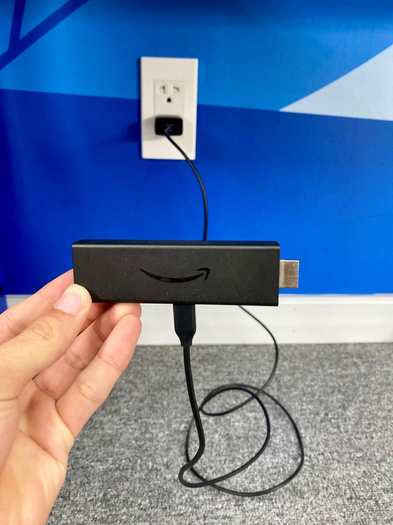 plugging the Fire Stick power adapter into a power outlet