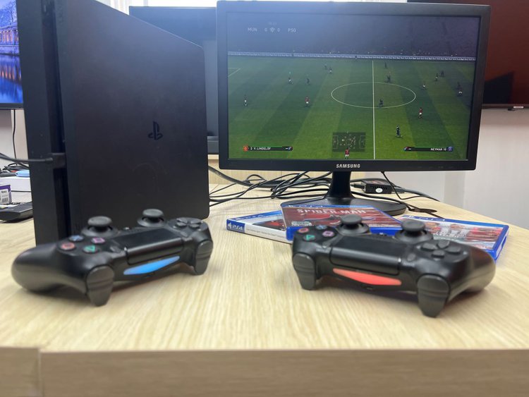 A PS4 console with a VGA monitor and controllers running efootball 2021