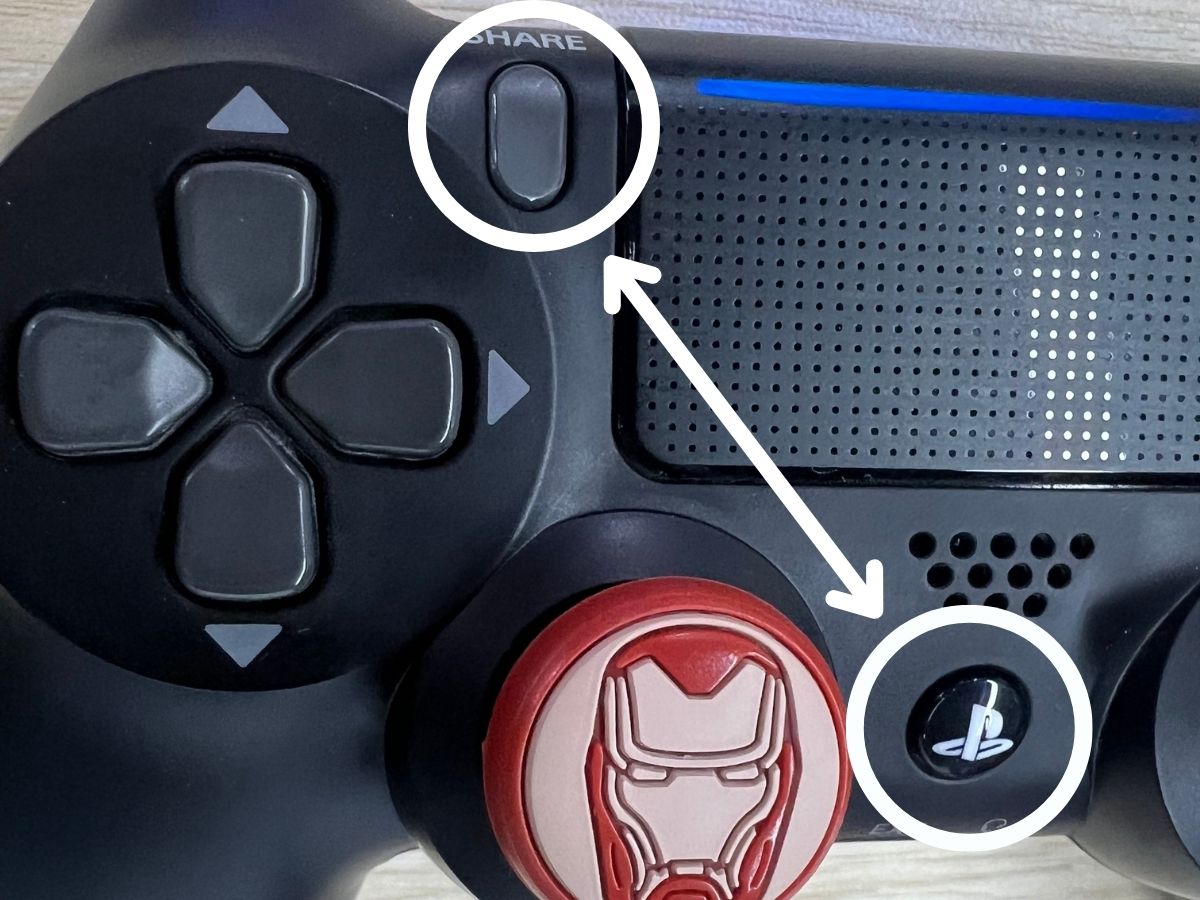 A PS4 controller with the share and PS buttons are highlighted with white circles