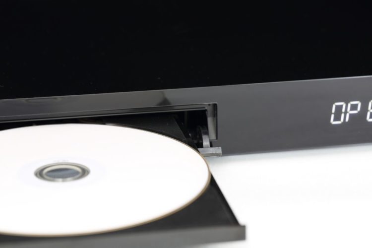 A black DVD player and a white disk