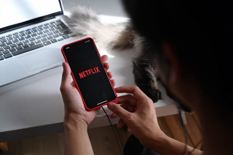 A girl turning Netflix on a smartphone