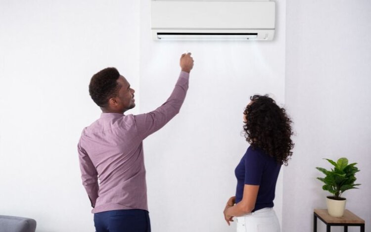 Man adjust air conditioner temperature