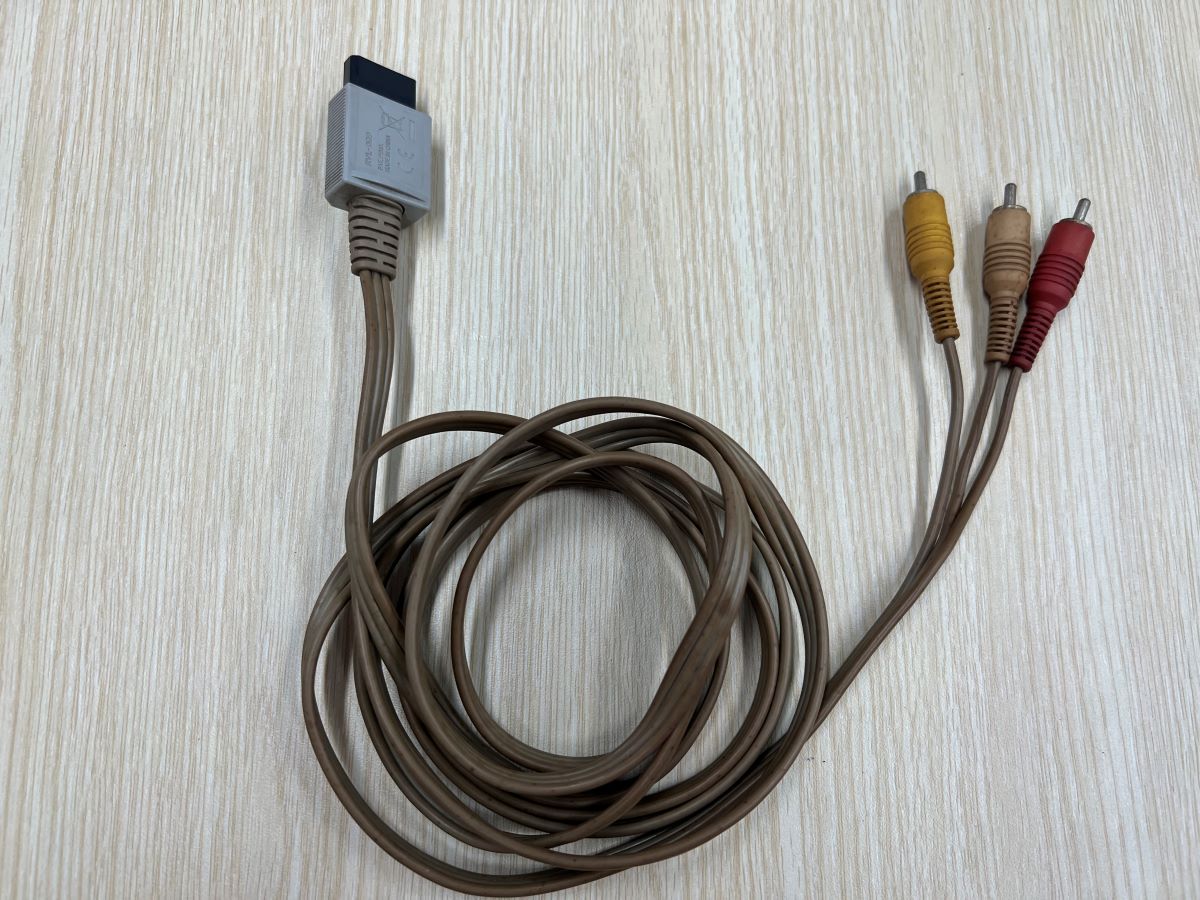 The RCA cable from Wii console is on a wooden table